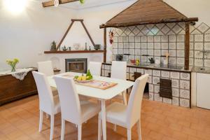 a kitchen and dining room with a white table and chairs at Casa Lalù - Rustic apartment with stunning views in Positano +24 photos