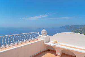 a white bench sitting on a balcony overlooking the ocean at Casa Lalù - Rustic apartment with stunning views in Positano