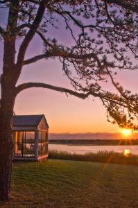 a house on the shore of a lake at sunset at The Dunes on the Waterfront in Ogunquit