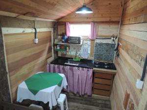 an interior view of a kitchen in a tiny house at Paiol - Tô na Roça - Junto á natureza!!! in Cunha