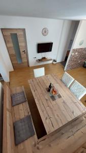 a living room with a wooden table and a flat screen tv at Apartments Ela in Rateče