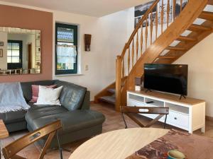a living room with a couch and a flat screen tv at Ferienhaus Prerow in Prerow