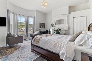 1 dormitorio blanco con 1 cama y 1 silla en McKay Manor on Duckworth en San Juan de Terranova
