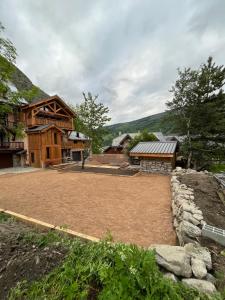 a large yard in front of a log cabin at L'Ascension - Appartement de standing avec vue "Les Aiguilles" in Valloire