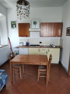eine Küche mit einem Holztisch und einigen Stühlen in der Unterkunft Agriturismo Le Cantine in Poggibonsi