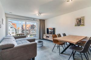 a living room with a couch and a table at Appartement Villa Creole Jachthaven Nieuwpoort in Nieuwpoort