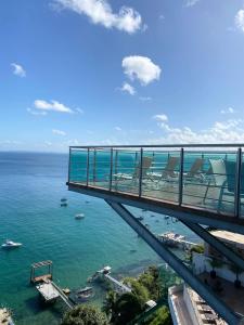 uma ponte sobre o oceano com barcos na água em Vitoria Loft 403 em Salvador