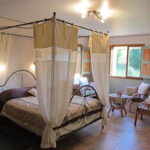 ein Schlafzimmer mit einem Himmelbett und ein Wohnzimmer in der Unterkunft Le Clos de Lumière in La Roche-des-Arnauds