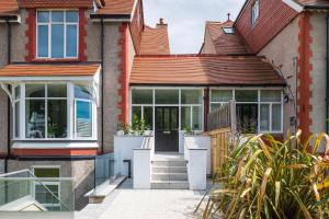 an extension to a house with glass doors at Midshore Boutique Holiday Apartment in Llandudno