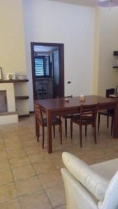 Casa vacanze ACQUAVIVA في Melizzano: غرفة طعام مع طاولة وكراسي خشبية