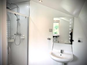 a bathroom with a sink and a shower and a mirror at Glamping at Shieling Holidays Mull in Craignure