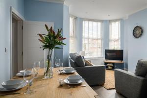 a living room with a wooden table with wine glasses at Midshore Boutique Holiday Apartment in Llandudno