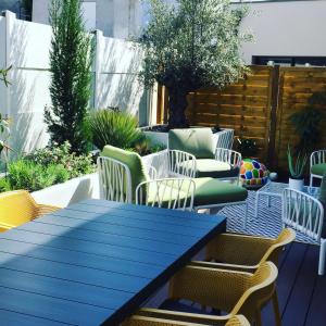 un patio con una mesa azul y sillas en Agréable maison neuve Angers Centre-Madeleine en Angers
