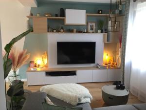 a living room with a flat screen tv on a shelf at Agréable maison neuve Angers Centre-Madeleine in Angers