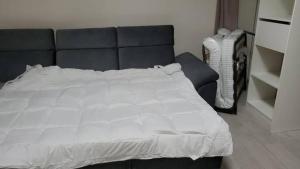 een slaapkamer met een groot wit bed met een zwart hoofdeinde bij maisonnette de 21m2 plus terrasse in Gentilly
