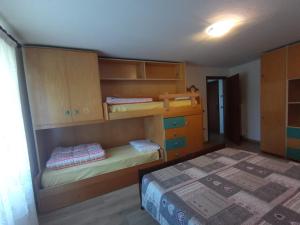 una camera con 2 letti a castello e un letto di Casa Ciclamino a Serrada