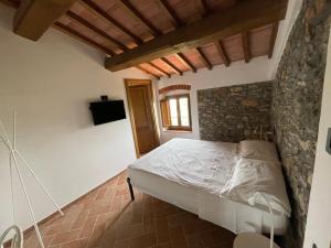 a bedroom with a bed and a stone wall at Affittacamere Il Vecchio Mandorlo in Montemagno
