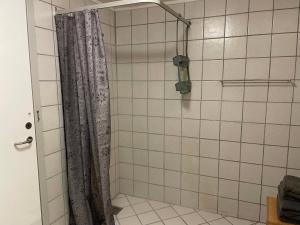 a bathroom with a shower with a shower curtain at Kragh B&B in Løsning