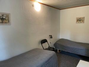 una camera con due letti e una sedia di Kragh B&B a Løsning