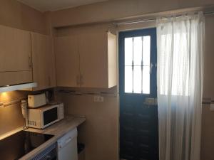 a kitchen with a blue door and a microwave at Casita La Playa in Málaga