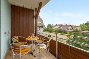 een balkon met een tafel en stoelen en uitzicht bij Apartamenty PIAMOLA Willa Turkusowa in Kąty Rybackie