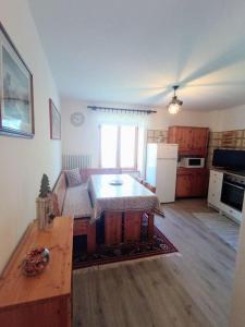 a living room with a table and a kitchen at Casa Ciclamino in Serrada