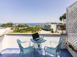 a table with a laptop on top of a balcony at Bristol Hotel in Ischia