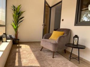 a living room with a chair and a yellow pillow at BLU Apartments in Bamako