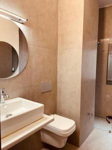 a bathroom with a sink and a toilet and a mirror at BLU Apartments in Bamako