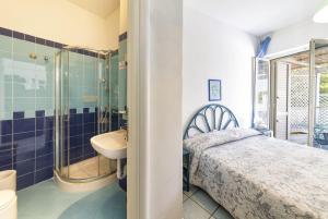 a bathroom with a bed and a sink and a shower at Bristol Hotel in Ischia