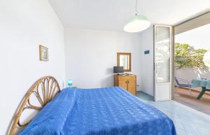 a bedroom with a blue bed and a sliding glass door at Bristol Hotel in Ischia