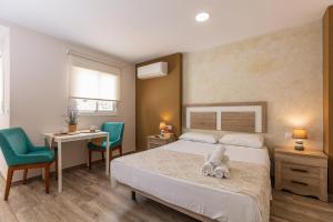 マラガにあるApartamentos Lola Beachのベッドルーム1室(ベッド1台、デスク、椅子付)