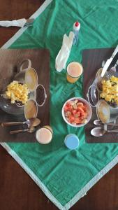 a table with plates of food on a green table cloth at Pousada Recanto Verde Cunha in Cunha