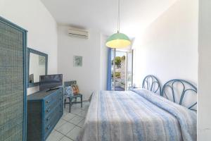 a bedroom with a bed and a desk and a mirror at Bristol Hotel in Ischia