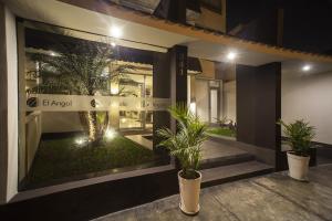 a building with two potted plants in front of it at El Angolo in Lima