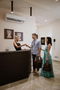 a group of people shaking hands in an art gallery at Sea Luxury Suites in Cefalù