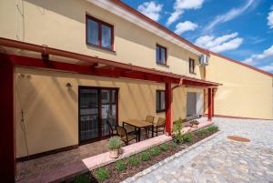 ein Haus mit einer Terrasse mit einem Tisch und Stühlen in der Unterkunft Penzion Kamenný dvůr in Třeboň