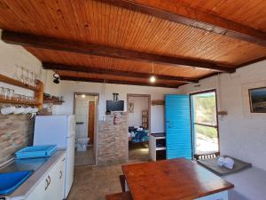 a kitchen with a wooden ceiling and a wooden table at Robinson house Ruža in Neviđane