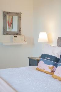 a bedroom with a bed with a mirror and a lamp at Duneden Cottage and Grounds in Randalstown