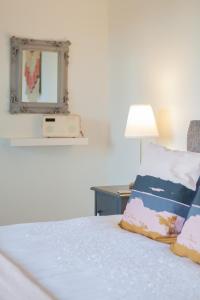a bedroom with a bed with a mirror and a lamp at Duneden Cottage and Grounds in Randalstown +25 photos