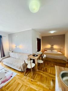 una camera con due letti, un tavolo e una vasca da bagno di Sunrise Apartments and Studios a Star Dojran