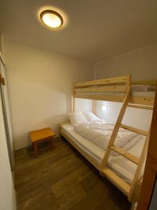 a bedroom with two bunk beds and a table at Valmeinier 1800 - Ecrin des neiges in Valmeinier