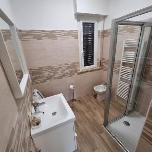 a bathroom with a sink and a shower and a toilet at Appartamento Corallo in Porto Recanati