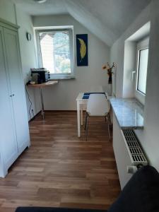 a room with a table and a kitchen with a table and a window at Apartment-Ferienwohnung 3 Treffen am Ossiachersee in Treffen