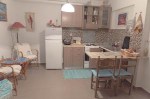 a kitchen with a white refrigerator and a table and chairs at Blue Horizon Dream in Thymonia Beach