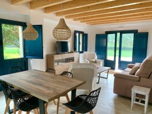 sala de estar con mesa de madera y sillas en Grandes Duplex nuevos con Jardin - 3 llaves, Los Gayoles Rural, en Castropol