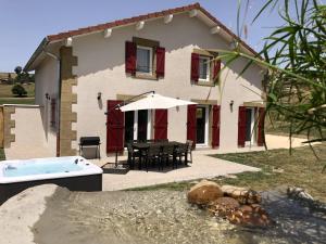 a house with a table and a tub in front of it at au gite de la cascade in Le Grand Serre
