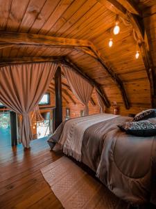 a bedroom with a bed in a wooden ceiling at Cabana estilo Celeiro em Urubici in Urubici