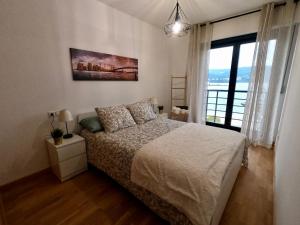 1 dormitorio con cama y ventana grande en Apartamento con balcón y vistas al mar en Viveiro