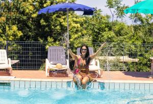 a woman is sitting in the water in a swimming pool at Bristol Hotel in Ischia